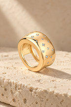 Gold Stromboli starburst ring cover on travertine