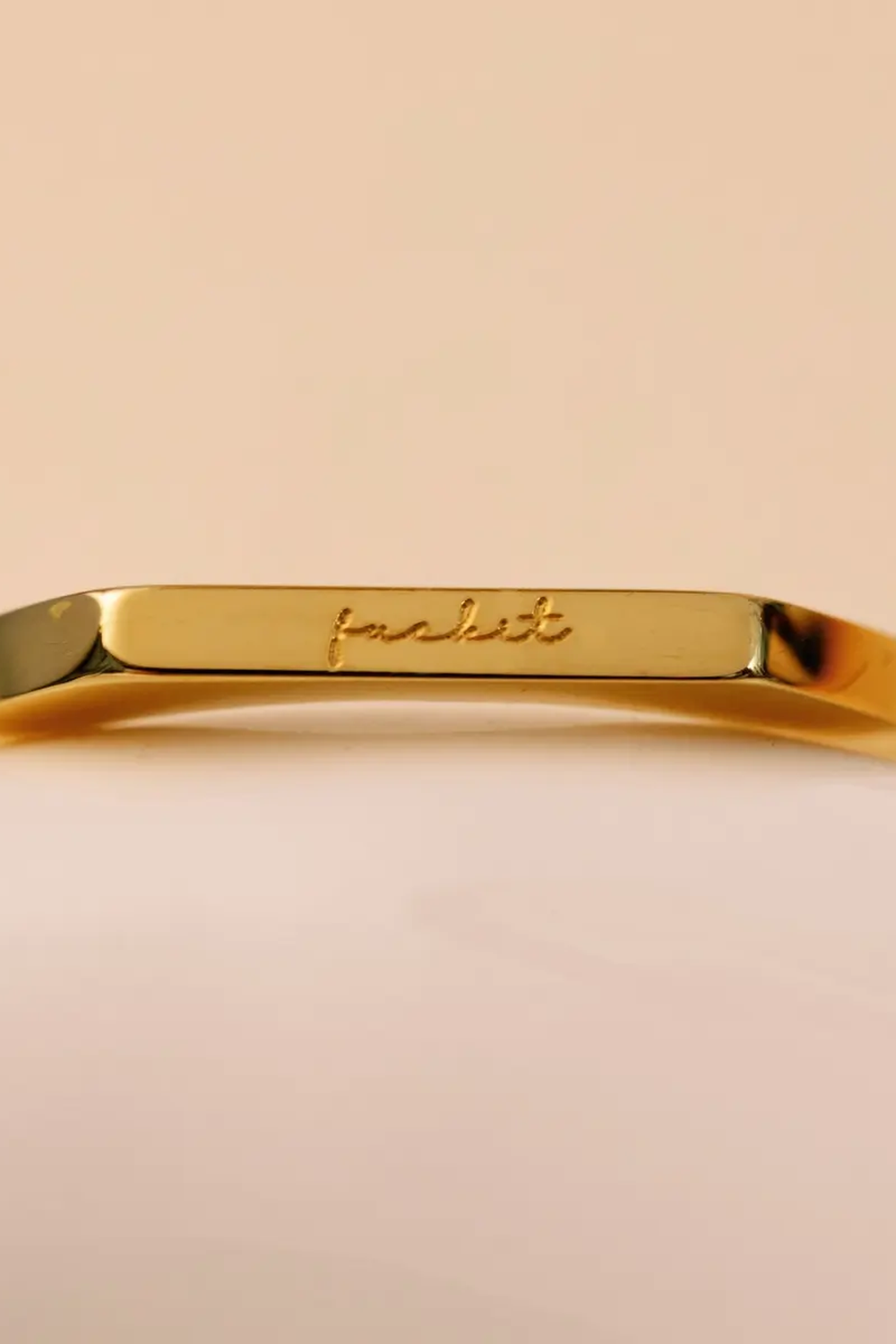 Close up of the cursive engraving on the flat top bar of the Basta Band