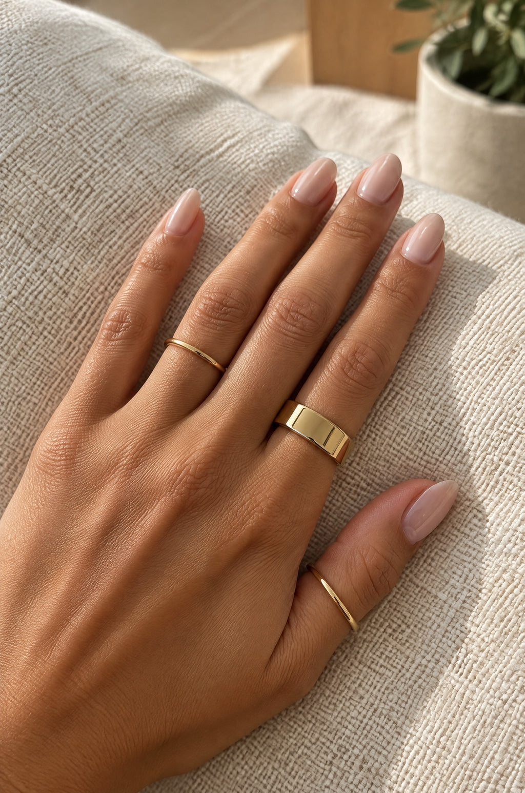 Hand wearing a gold Faraglioni cover