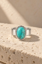 Giglio ring cover with a turquoise stone on travertine
