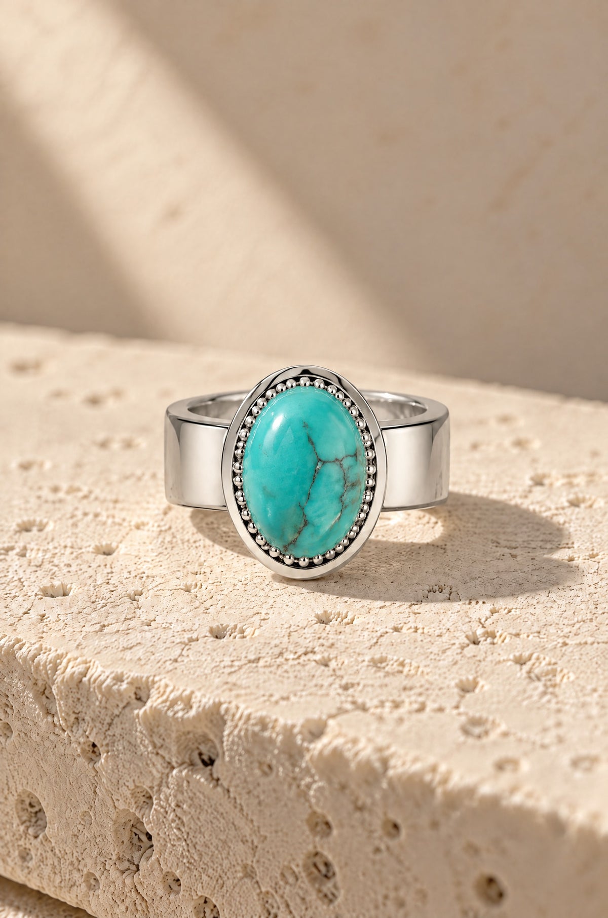 Giglio ring cover with a turquoise stone on travertine