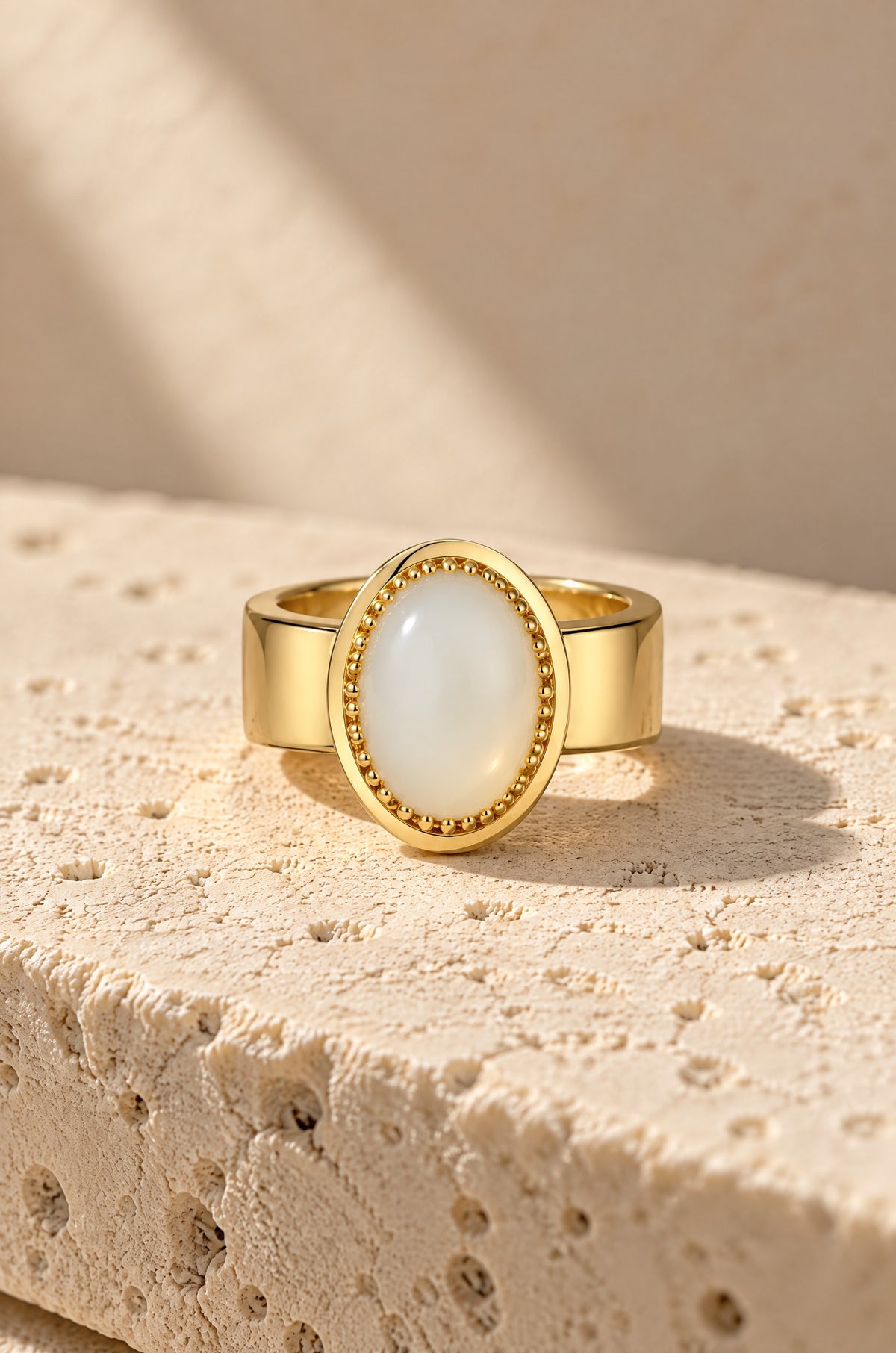 Giglio ring cover in gold with an opal-white stone