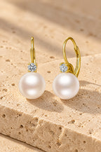 Panarea pearl drop earrings, yellow gold, on travertine