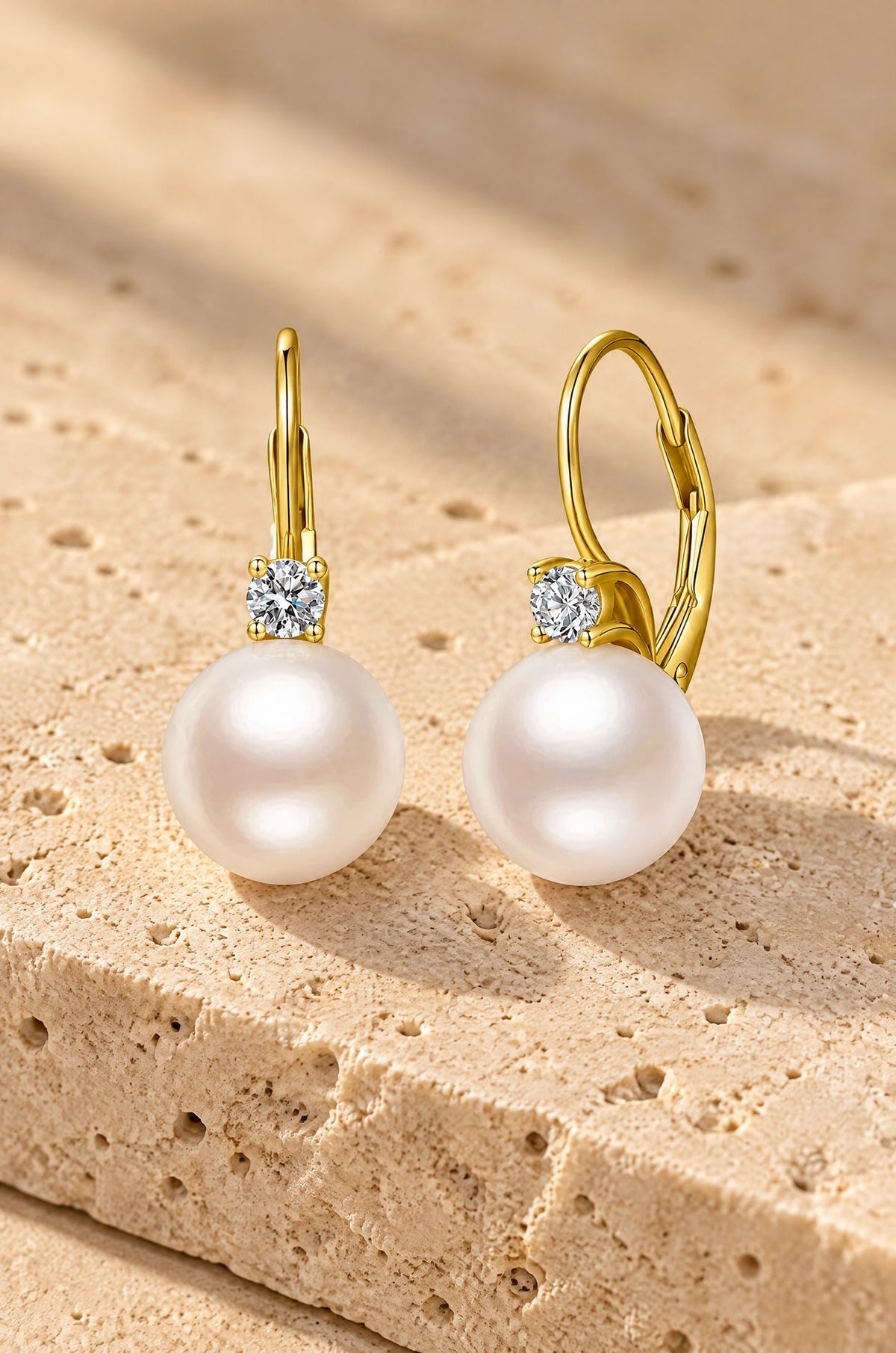 Panarea pearl drop earrings, yellow gold, on travertine