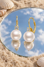 Panarea pearl drop earrings, yellow gold, on a mirror in the sand