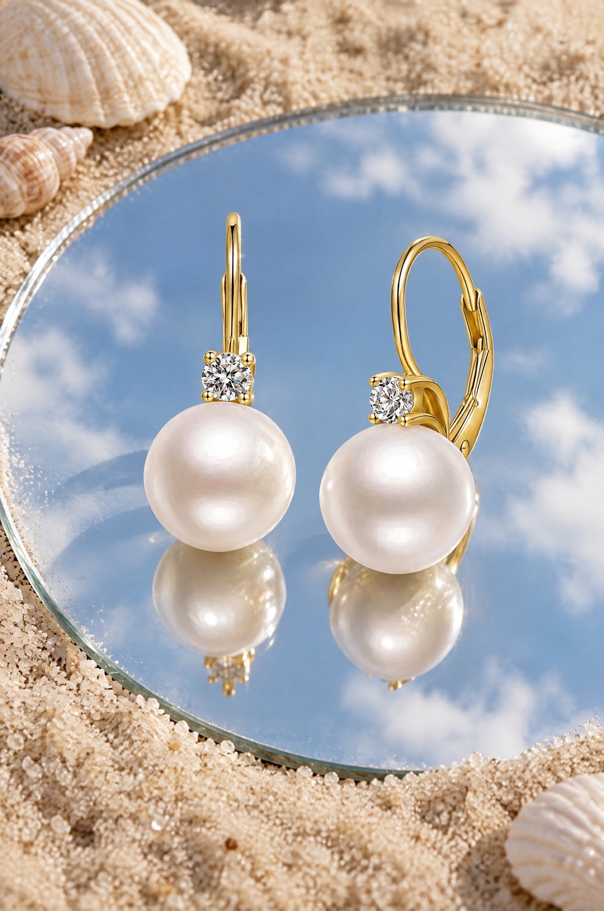 Panarea pearl drop earrings, yellow gold, on a mirror in the sand
