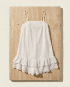 Praiano eyelet romper on warm travertine stone